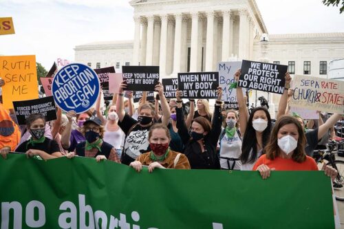 Demonstrators protest on the steps of the Supreme Court.