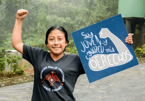 woman in a black t-shirt holding a sign.
