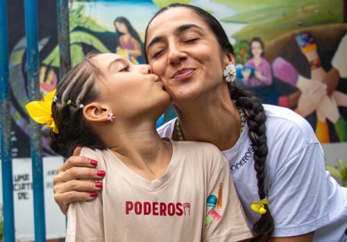 image of small girl kissing the cheek of an older woman smiling